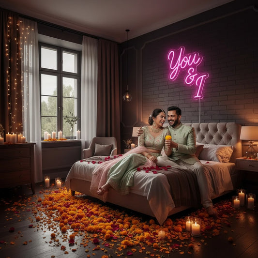 Lux Neon You and I neon sign in bright pink script, mounted on a brick wall above a bed.