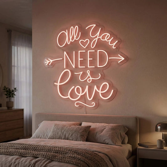 Neon sign with 'All You Need Is Love' in a bedroom setting
